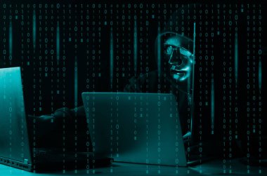 Hacker ve kötü amaçlı yazılım konsepti. Tehlikeli Kapüşonlu hacker ikili kod dijital arayüzü olan dizüstü bilgisayar kullanıyor..