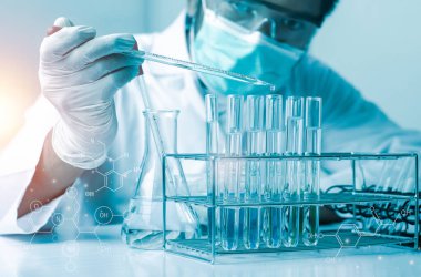 Bilim adamlarının el ele tutuştuğu pipette deney tüpü ve bilimsel deneylerin içine kimyasal sıvı içeren bir örnek bırakıyor., 