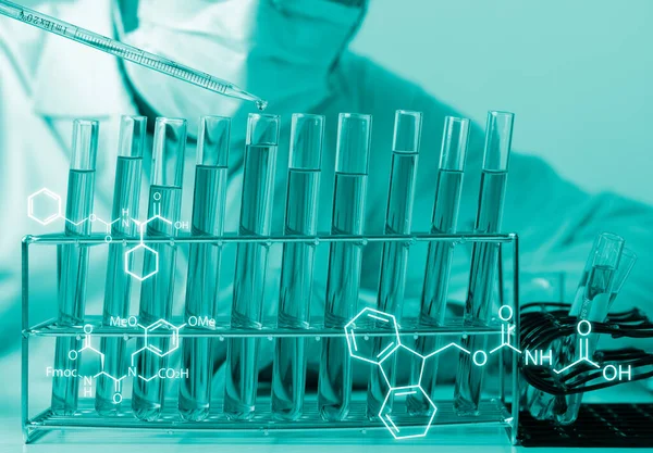 Bilim adamlarının el ele tutuştuğu pipette deney tüpü ve bilimsel deneylerin içine kimyasal sıvı içeren bir örnek bırakıyor., 