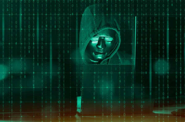Hacker ve kötü amaçlı yazılım konsepti. Tehlikeli Kapüşonlu hacker ikili kod dijital arayüzü olan dizüstü bilgisayar kullanıyor..