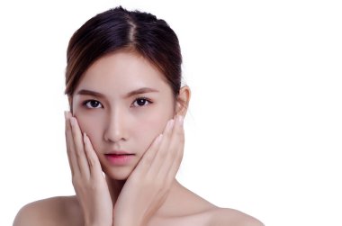 Kısa saçlı, Asyalı güzel bir kadın gülümseyip yüzüne dokunuyor, beyaz arka planda soyutlanmış. Doğal makyaj, SPA terapisi, cilt bakımı, kozmetoloji ve estetik cerrahi konsepti