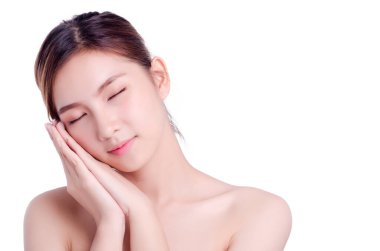 Kısa saçlı, Asyalı güzel bir kadın gülümseyip yüzüne dokunuyor, beyaz arka planda soyutlanmış. Doğal makyaj, SPA terapisi, cilt bakımı, kozmetoloji ve estetik cerrahi konsepti