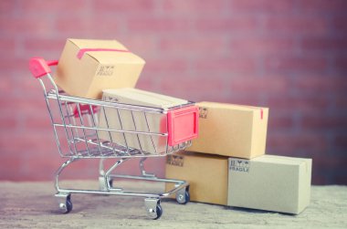 Alış veriş arabasındaki karton kutular ahşap masa, e-ticaret veya elektronik ticaret internet üzerinden mal veya hizmet satın alma veya satma işlemidir..
