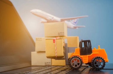 Laptop klavyesinde kutuları olan forklift kamyonu, lojistik ihracat ve ulaşım sanayii konsepti arka planına ilişkin fikirler.