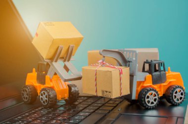 Laptop klavyesinde kutuları olan forklift kamyonu, lojistik ihracat ve ulaşım sanayii konsepti arka planına ilişkin fikirler.