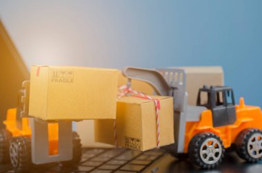 Laptop klavyesinde kutuları olan forklift kamyonu, lojistik ihracat ve ulaşım sanayii konsepti arka planına ilişkin fikirler.