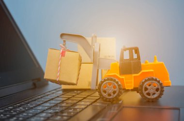 Laptop klavyesinde kutuları olan forklift kamyonu, lojistik ihracat ve ulaşım sanayii konsepti arka planına ilişkin fikirler.