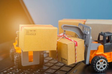 Laptop klavyesinde kutuları olan forklift kamyonu, lojistik ihracat ve ulaşım sanayii konsepti arka planına ilişkin fikirler.
