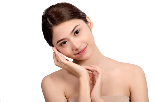Kısa saçlı, Asyalı güzel bir kadın gülümseyip yüzüne dokunuyor, beyaz arka planda soyutlanmış. Doğal makyaj, SPA terapisi, cilt bakımı, kozmetoloji ve estetik cerrahi konsepti
