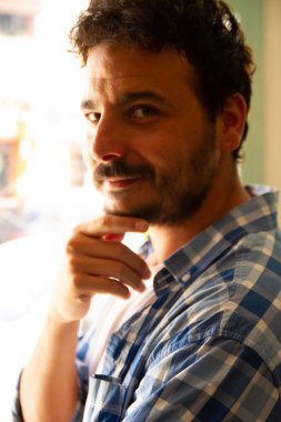 Bir kahve dükkanında doğal pencere ışığı ile Portre gülümseyerek