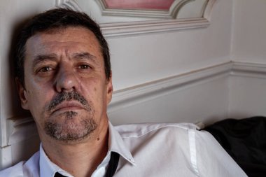 Oturan ciddi adam duvara düştü