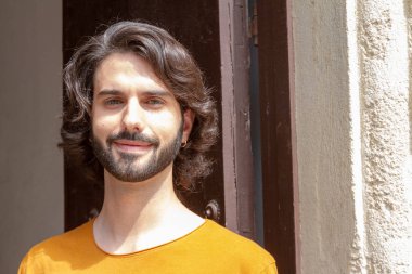 sokakta genç bir adamın portreleri, bir t-shirt turuncu ile gülümseme kamera bakarken