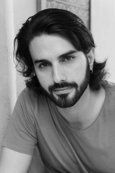 портреты молодого человека на террасе, смотрящего на камеру в черно-белом цвете, как актеры 40-х годов 50-х годов
