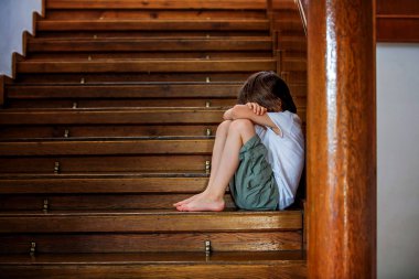Üzgün çocuk, büyük bir ev, zorbalık, depresyon stres veya hayal kırıklığı için konsept bir merdiven üzerinde oturan