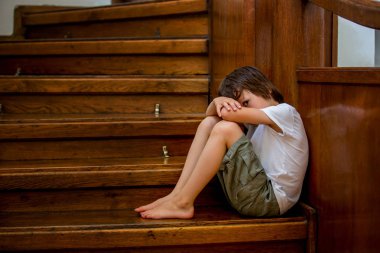 Üzgün çocuk, büyük bir ev, zorbalık, depresyon stres veya hayal kırıklığı için konsept bir merdiven üzerinde oturan