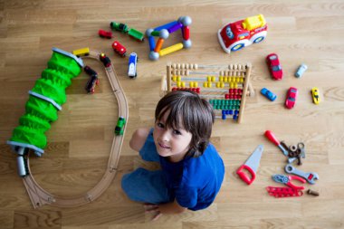 Okul öncesi çocuk abaküs ve diğer oyuncaklar ile oynama, ahşap katta oturan, üstten görüntülemek. Eğitim kavramı