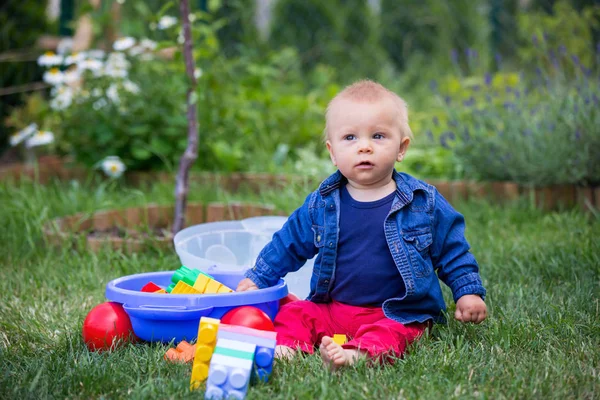 Farklı şekiller bina bahçe içinde büyük inşaat ile oynarken küçük oğlu, engeller