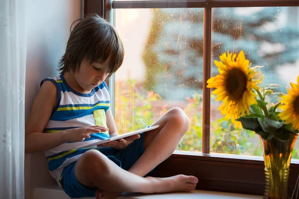 Criança Pequena Bonito Jogando Tablet Uma Janela Pôr Sol — Fotografia de Stock