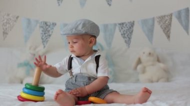 Şirin yürümeye başlayan çocuk, Bebek Çocuk, güneşli yatak, renkli oyuncakla oynarken bayrak afiş arkasında dekorasyon.