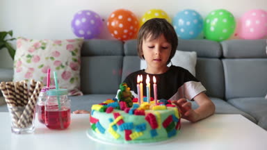 Sevimli çocuk, okul öncesi çocuk, renkli pasta, mumlar, evde balonlar ile onun Doğum günü kutluyor