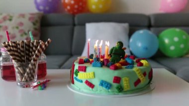 Sevimli çocuk, okul öncesi çocuk, renkli pasta, mumlar, evde balonlar ile onun Doğum günü kutluyor