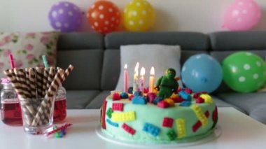 Sevimli çocuk, okul öncesi çocuk, renkli pasta, mumlar, evde balonlar ile onun Doğum günü kutluyor