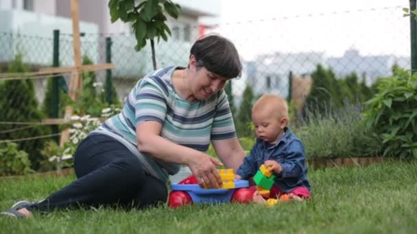 Little Baby Boy Playing His Grandmother Big Construction Blocks Garden — Stock Video