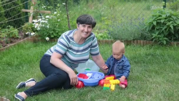 Little Baby Boy Playing His Grandmother Big Construction Blocks Garden — Stock Video