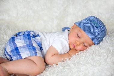 Şapkalı evde yatakta uyuyan sevimli bebek çocuk,