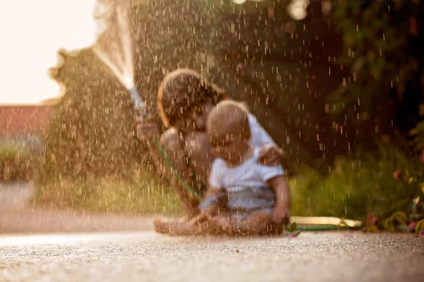 Adorables Niños Pequeños Hermanos Jugando Juntos Con Una Manguera Jardín —  Fotos de Stock