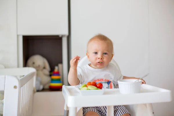 甘い赤ん坊 マッシュ食品と子供の部屋でベビー用ハイチェアに座って 新鮮な野菜を食べる — ストック写真