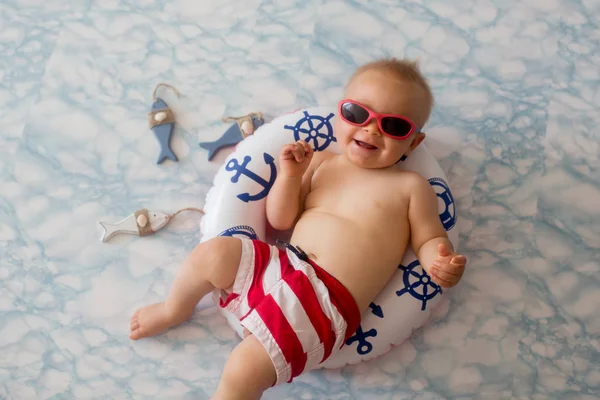귀여운 아기는 반지에 수영복 반바지와 선글라스 — 스톡 사진