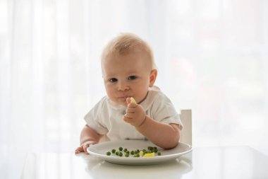 Yürümeye başlayan çocuk, beyaz gömlek, sevimli çocuk evde, bezelye yemek geri yaktı