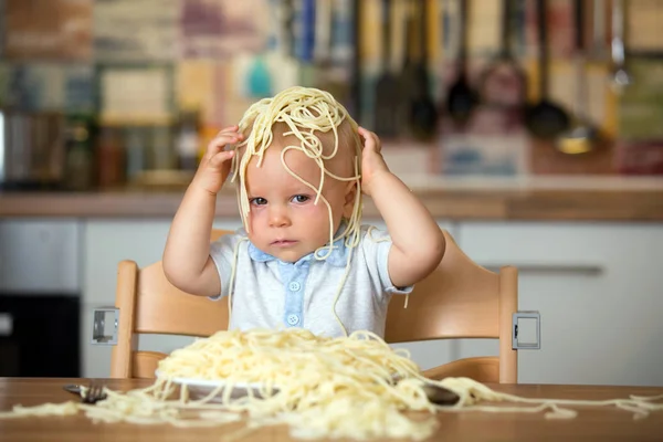幼児子供用の小さな男の子 昼食にスパゲッティを食べるとキッチンの家に混乱を作って — ストック写真