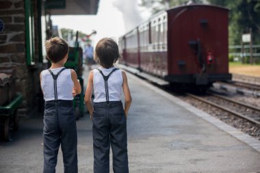 Güzel çocuk, giyinmiş vintage giysiler içinde eski buharlı tren sıcak yaz günlerinde İngiltere'de zevk.