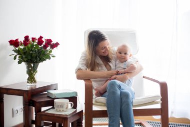 Anne, ona kitap okumak onun bebek çocuk sallanan sandalyede ile oynarken