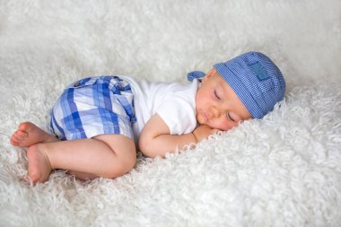 Şapkalı evde yatakta uyuyan sevimli bebek çocuk,