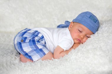 Şapkalı evde yatakta uyuyan sevimli bebek çocuk,