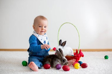 Bunnies ve evde, yumurta ile yumurta üzerinde renkli el çizimleri oynayan küçük yürümeye başlayan çocuk, bebek çocuk,