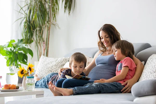 Joven Embarazada Leyendo Libro Casa Sus Dos Hijos Comiendo Frutas — Foto de Stock