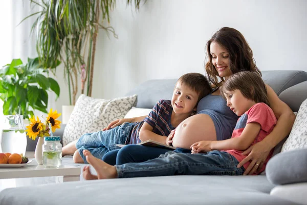 Joven Embarazada Leyendo Libro Casa Sus Dos Hijos Comiendo Frutas — Foto de Stock