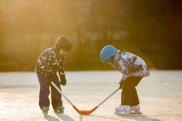 男の子 友人や兄弟ホッケーと凍った湖の公園で夕日冬スケート — ストック写真