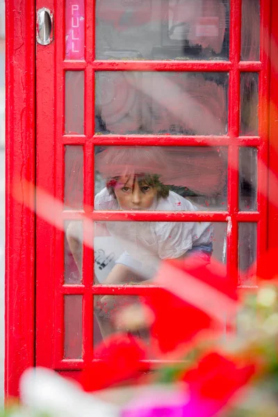 Χαριτωμένο Αγόρι Παιδί Καλώντας Από Ένα Κόκκινο Τηλεφωνικό Θάλαμο Στην — Φωτογραφία Αρχείου