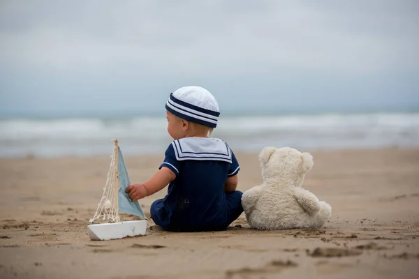 Niño Sentado Playa Cerca Del Agua Juega Con Barco Juguete —  Fotos de Stock