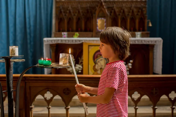少年が祈るし 正教会の信仰と悲しい子供にキャンドルを置く — ストック写真