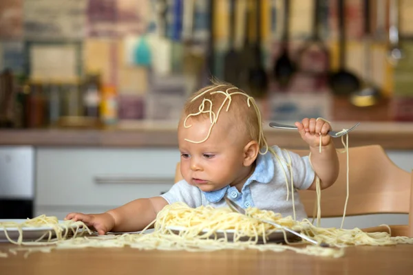 幼児子供用の小さな男の子 昼食にスパゲッティを食べるとキッチンの家に混乱を作って — ストック写真