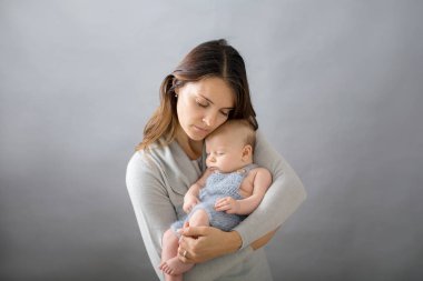 Onun yeni doğan bebek çocuk okşama, onun kollarında etrafında ve mutluluktan gülümseyen genç anne,