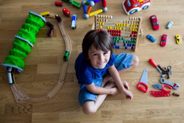Okul öncesi çocuk abaküs ve diğer oyuncaklar ile oynama, ahşap katta oturan, üstten görüntülemek. Eğitim kavramı
