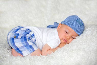 Şapkalı evde yatakta uyuyan sevimli bebek çocuk,