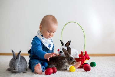Bunnies ve evde, yumurta ile yumurta üzerinde renkli el çizimleri oynayan küçük yürümeye başlayan çocuk, bebek çocuk,